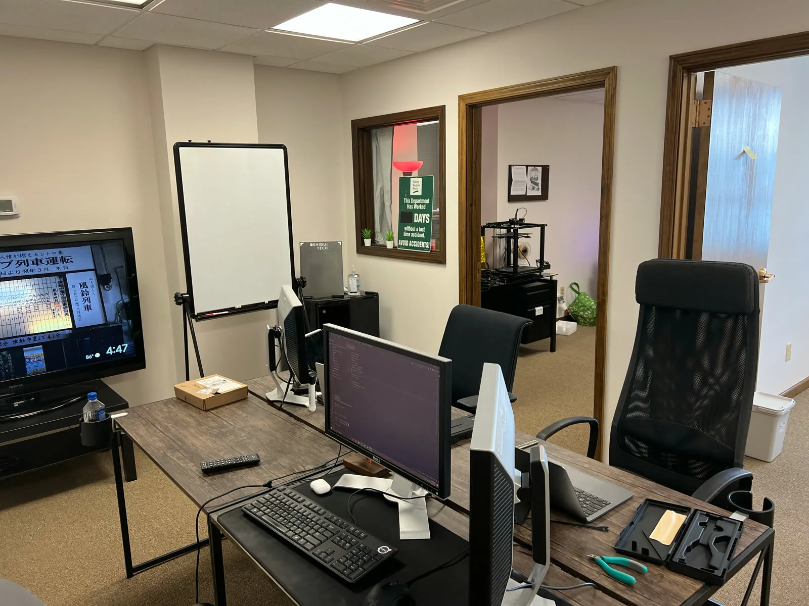 The Shibui Tech office in Bloomington, Indiana: CAD workstations, a planning whiteboard, and a 3D printer running in the next room, a real shop rather than a showroom